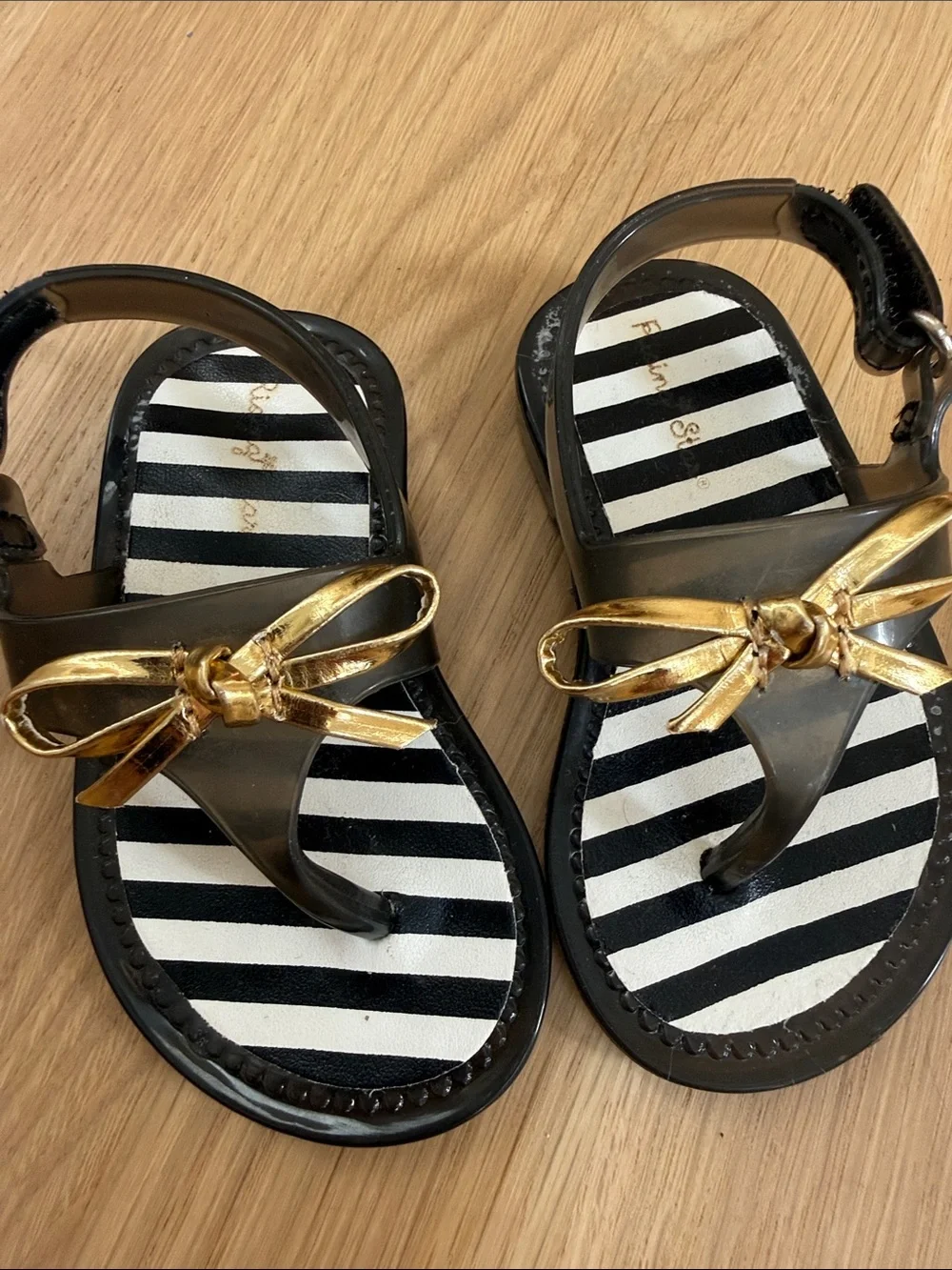Rising Star Black Sandals with Gold Bow and Striped Footbed